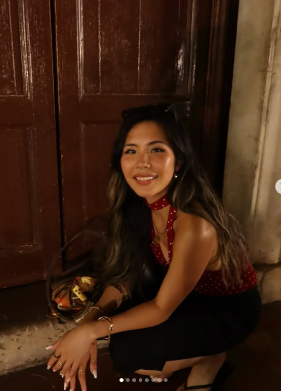 Cathy smiling in a red scarf and black outfit